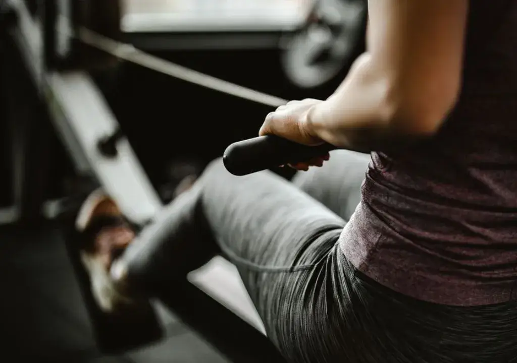 woman uses rowing machine in the gym