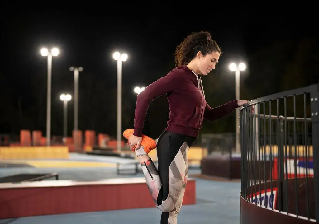 woman stretching her leg at night